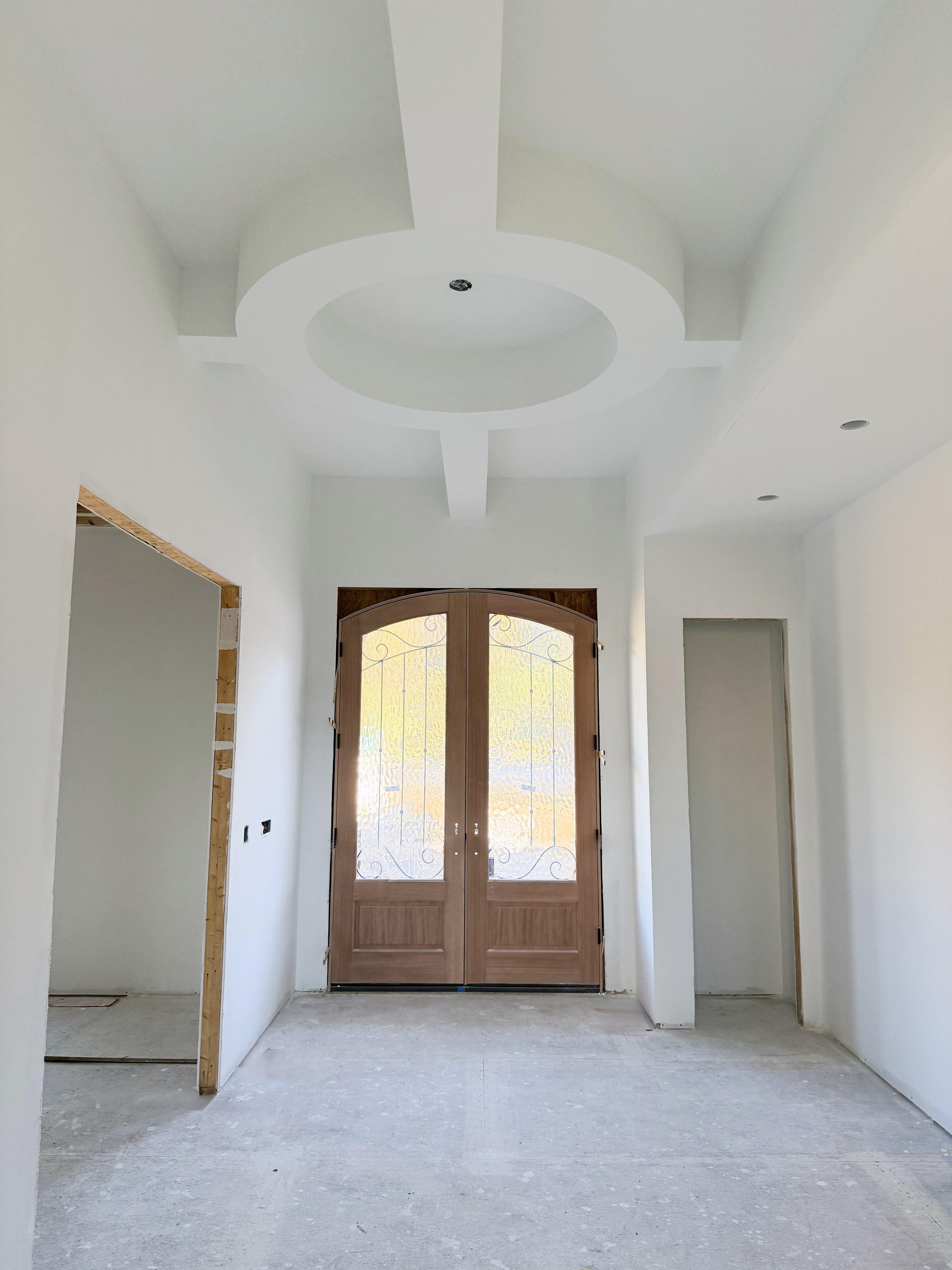 New build: entry foyer with a round tray ceiling and arched double front doors, drywall finished by Thal & Sons